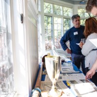 People looks at old photos from GVSU Rowing over the years